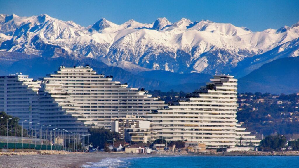 The property complex Marina Baie des Anges with snowy mountains in the background
