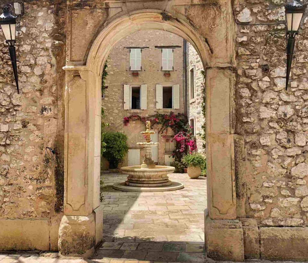 Passage to the courtyard with a fountain and chateau Villenueve / the town hall in Tourettes-sur-loup