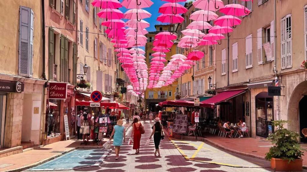 Lyserøde paraplyer i Grasse's gader