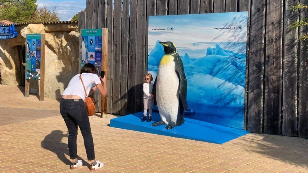 Une petite fille est photographiée avec un pingouin au Marineland Antibes