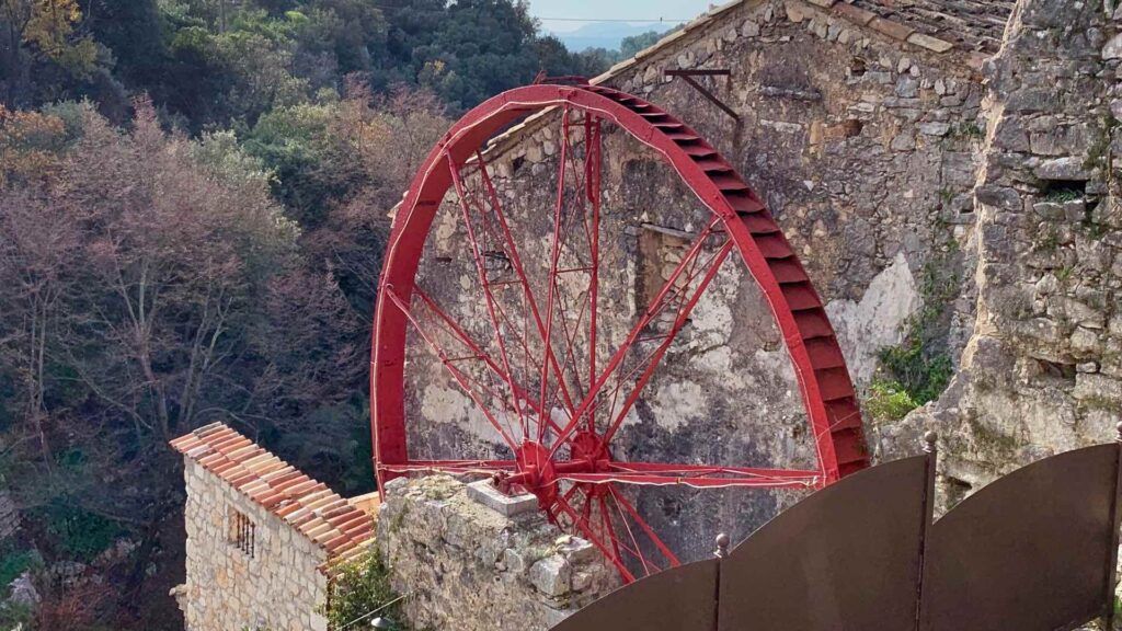 The red iron olive mill wheel in Tourettes-sur-Loup in adjunction to an aqueduct